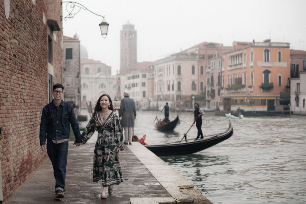 Couple walking hand in hand beside the Grand Canal during a romantic photoshoot in Venice