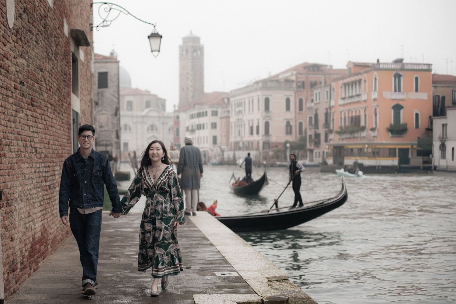 Couple walking hand in hand beside the Grand Canal during a romantic photoshoot in Venice