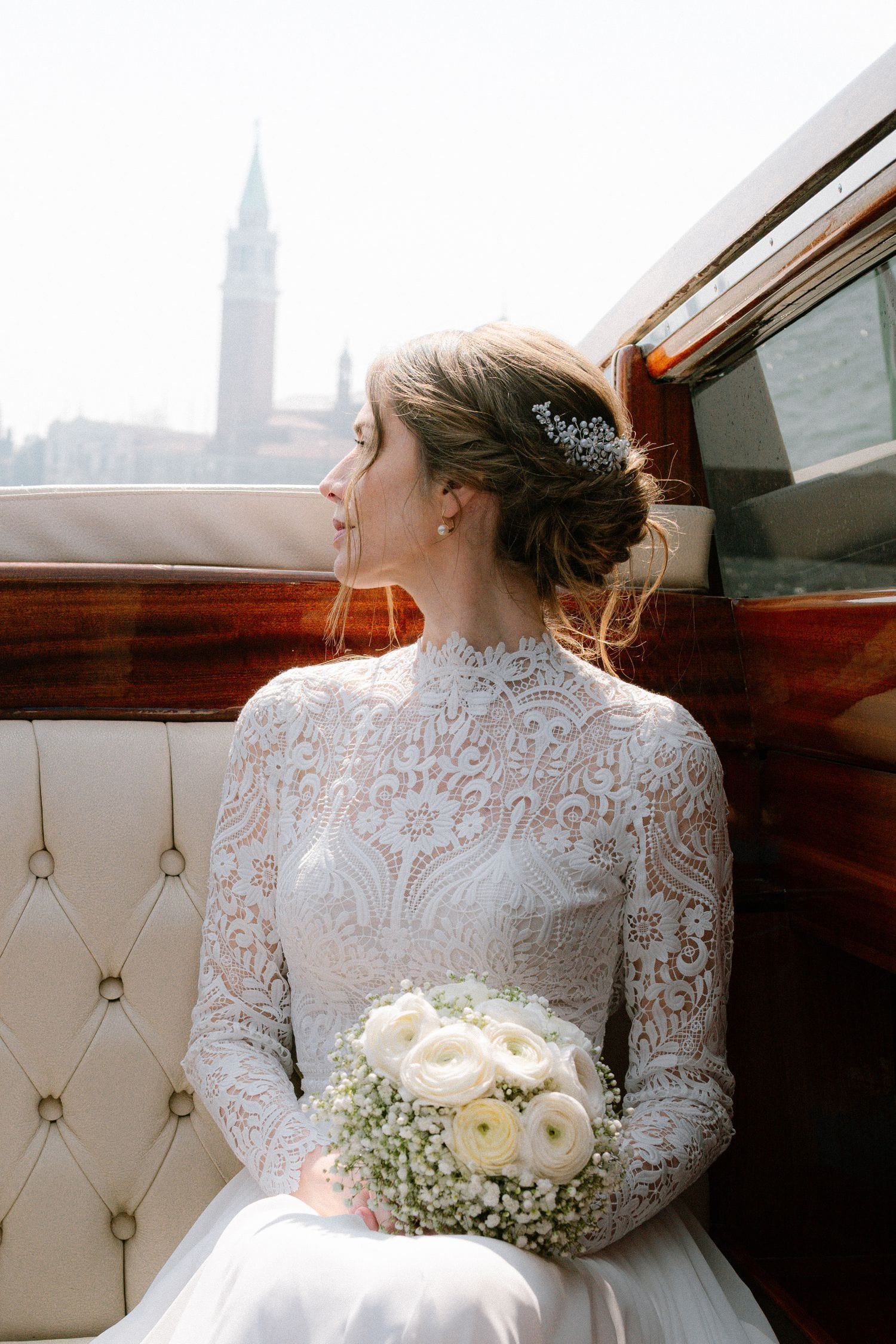 Sposa con bouquet bianco in taxi acqueo a Venezia