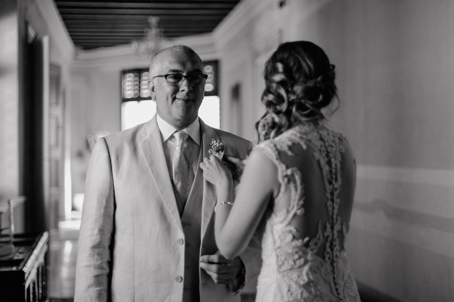 Black and white photo showing an emotional first look moment between a bride and someone in a light color suit.