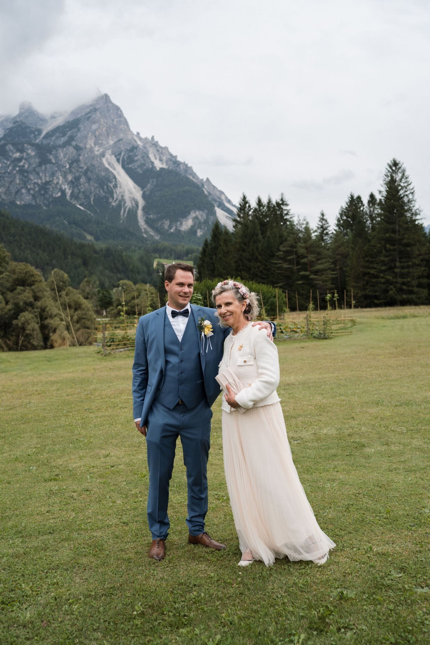 Bride and groom portrait in Cortina by a Dolomites wedding photographer with alpine peaks behind them