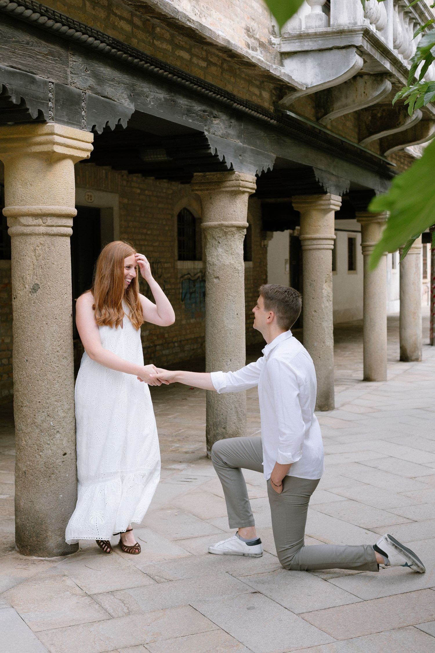 Elegant scene under historic Italian colonnade with stone pillars creating dramatic shadows and depth.