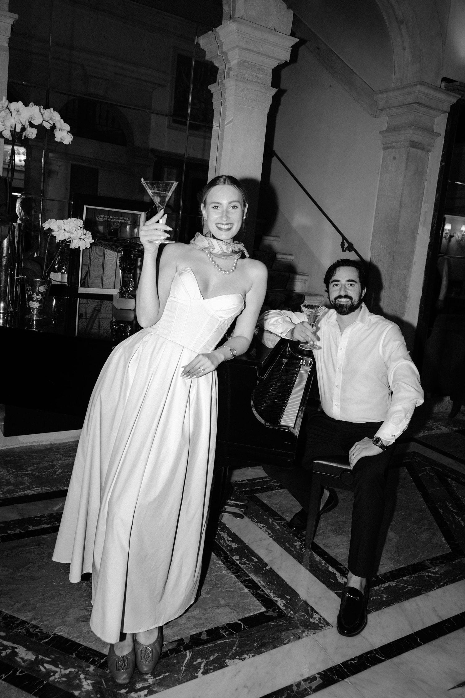 Couple celebrating their Venice engagement with cocktails in an elegant hotel interior