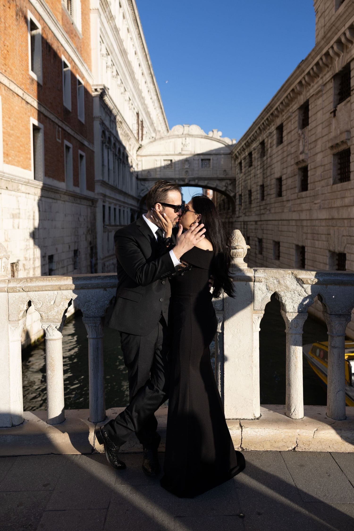 Couple kissing near the Bridge of Sighs during an editorial Venice photoshoot