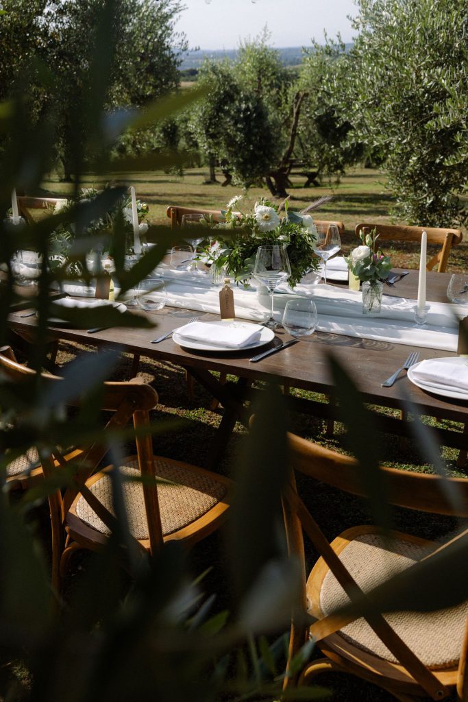 Tuscan wedding table setting with white flowers and olive groves near Siena