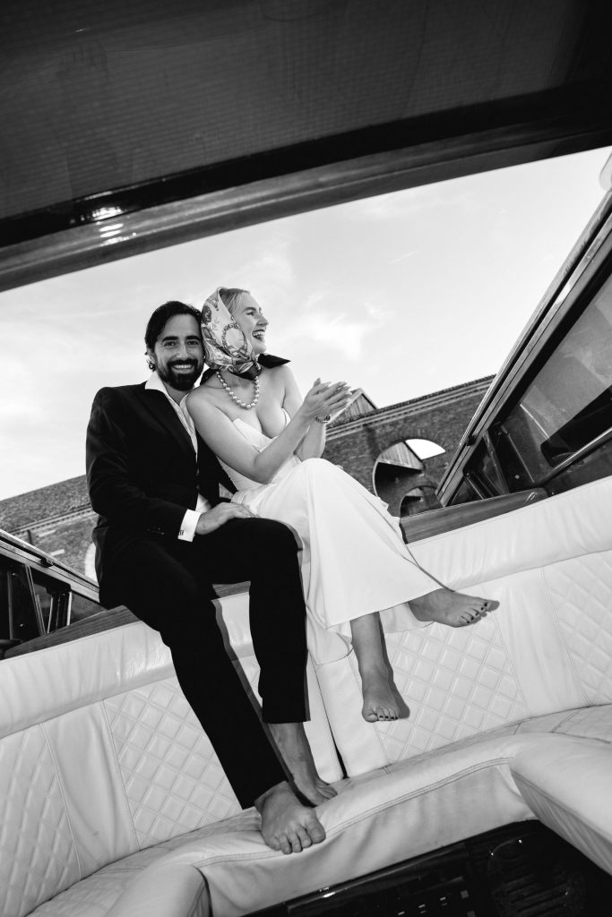 Black and white portrait of a couple on a Venetian water taxi after their proposal