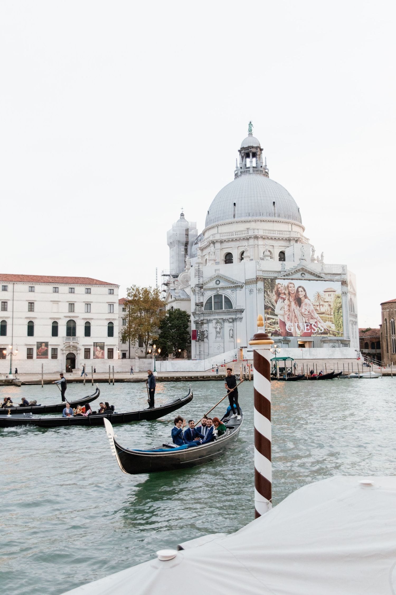 Gondolas gliding along the Grand Canal in Venice with the iconic Santa Maria della Salute basilica in the background.