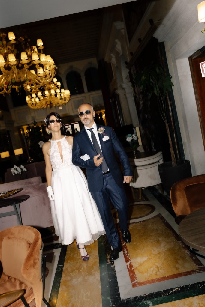 Direct-flash portrait of the newlyweds at the reception room entrance