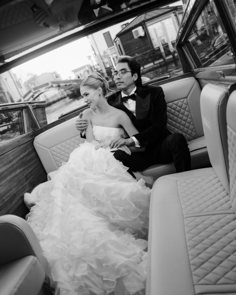 Palazzo dei Dogi wedding couple seated aboard a wooden boat in Venice
