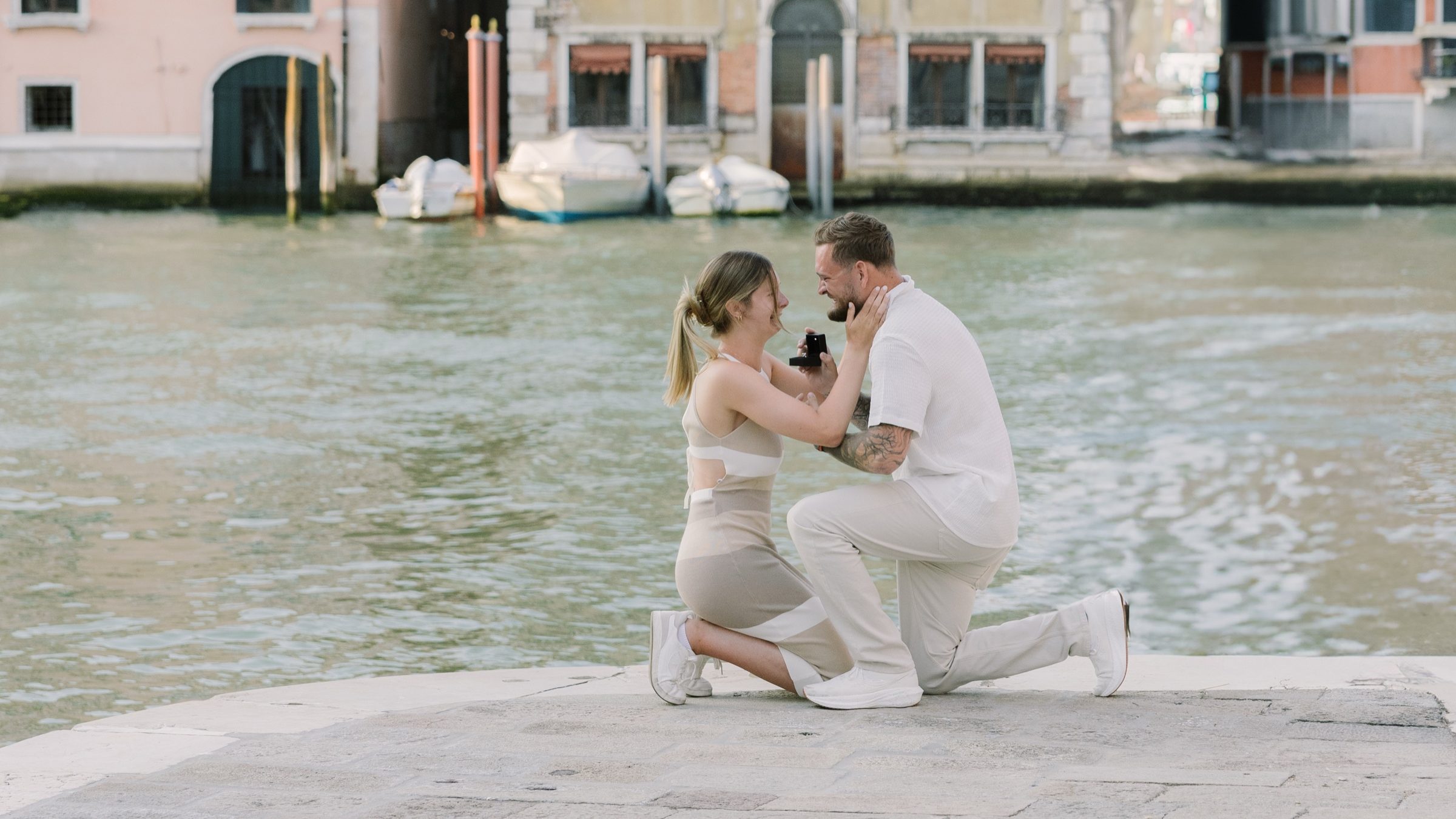 Joseph kneeling beside the Grand Canal as he surprises Gianna with a marriage proposal in Venice