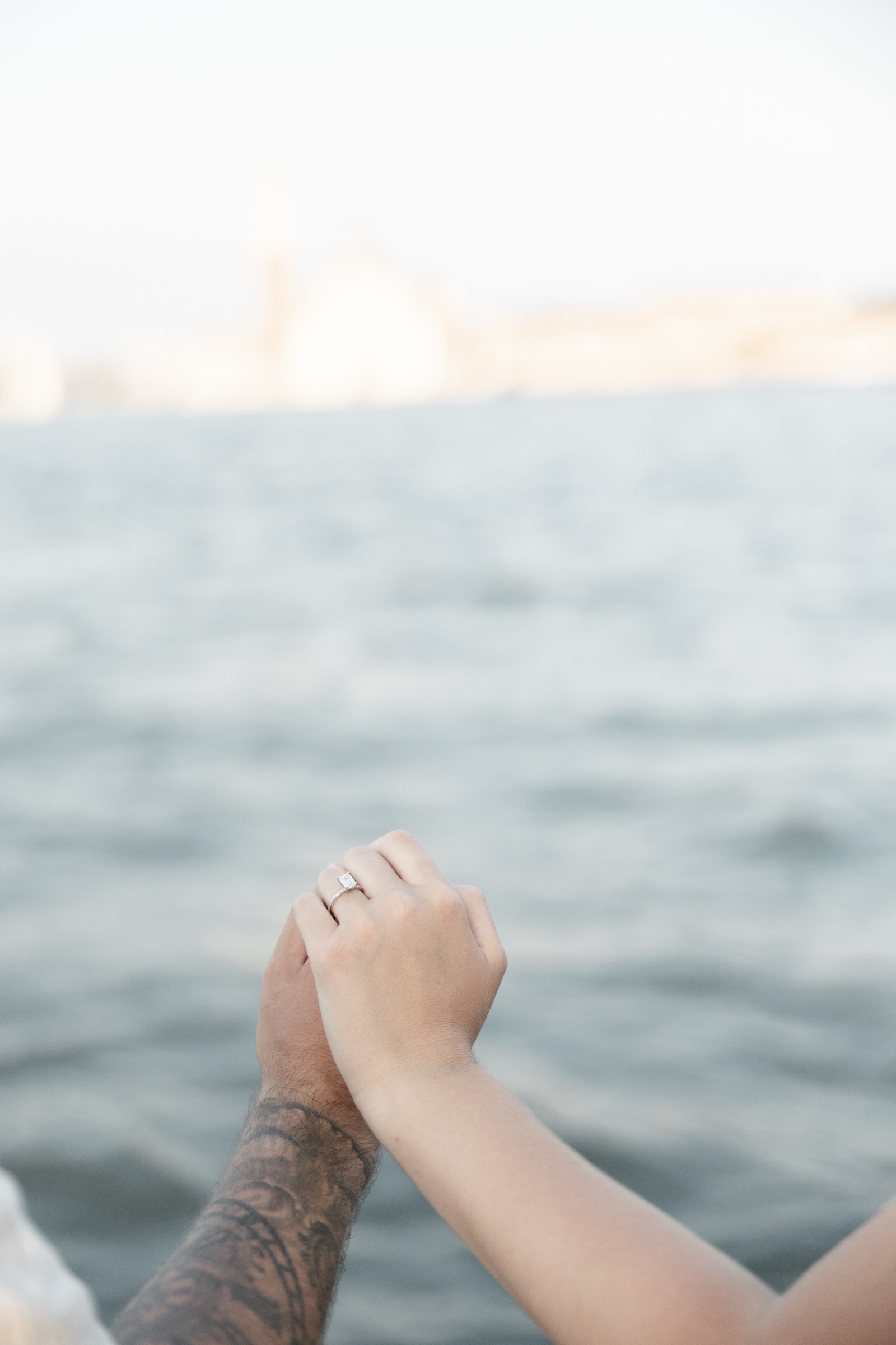 Joseph and Gianna holding hands with her engagement ring visible above the Venetian lagoon