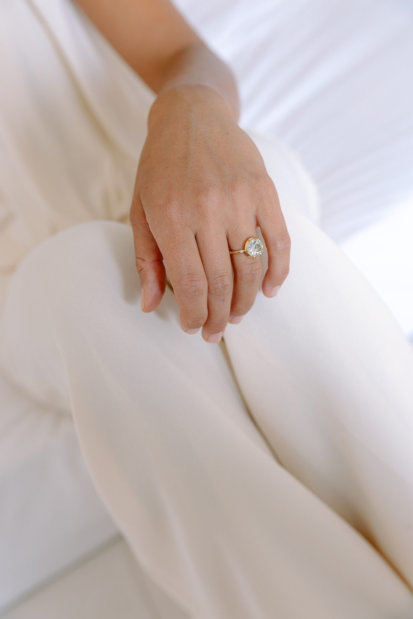 Dettaglio della mano e dell’anello di Allegra sul completo bianco